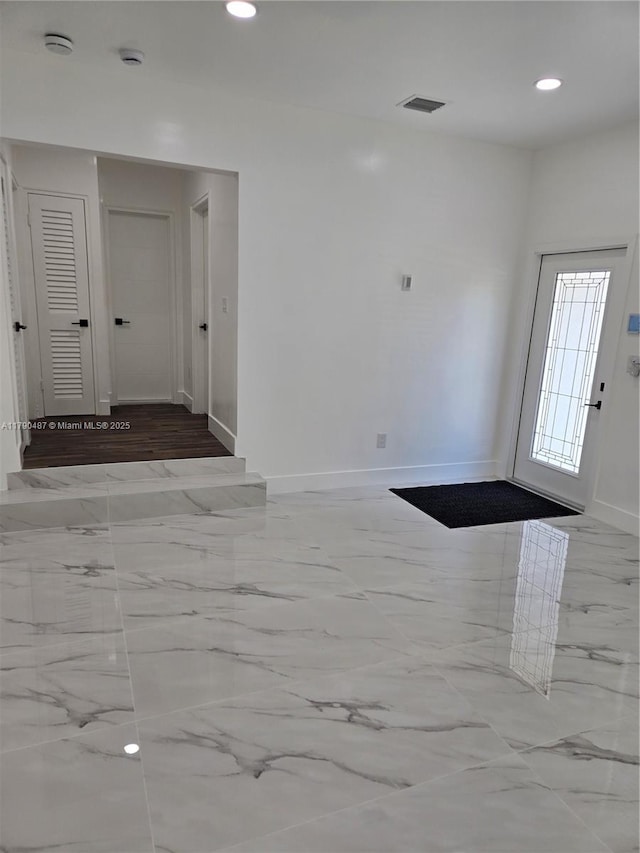 foyer entrance with baseboards, marble finish floor, recessed lighting, and visible vents
