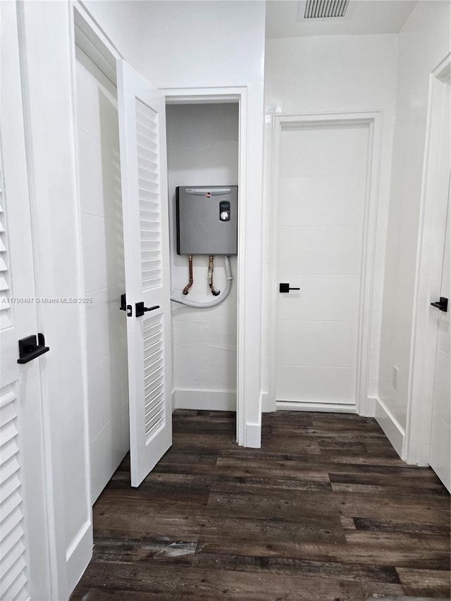 interior space with baseboards, wood finished floors, and visible vents