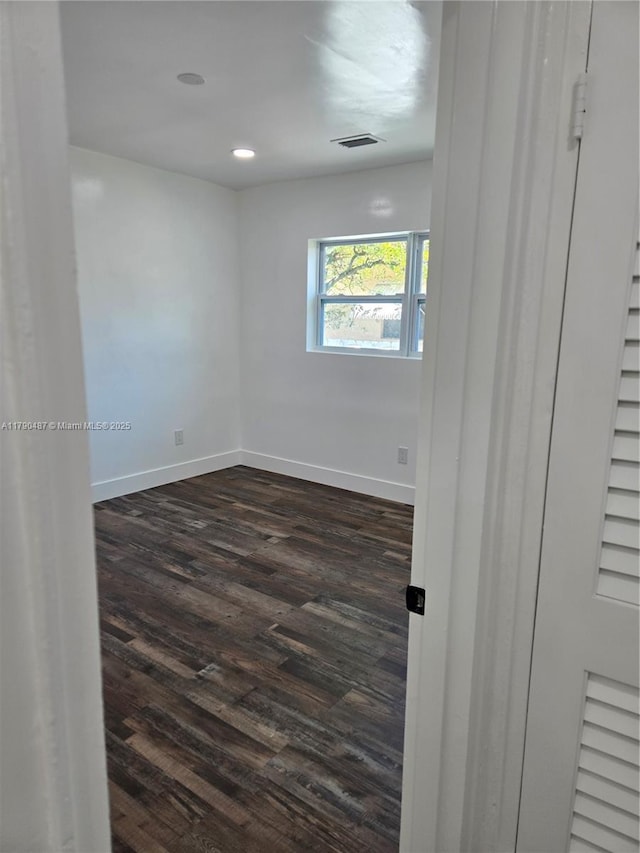 empty room featuring recessed lighting, baseboards, visible vents, and dark wood finished floors