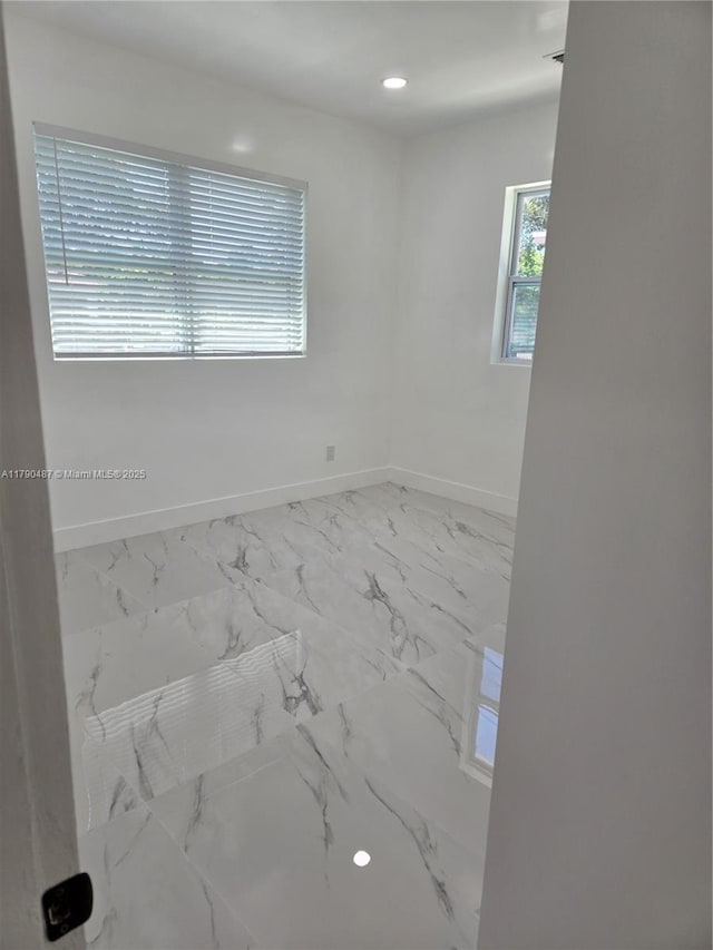spare room featuring baseboards, recessed lighting, and marble finish floor