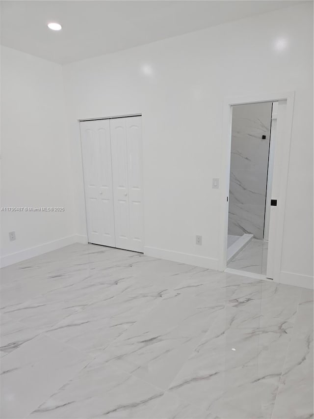 spare room featuring recessed lighting, baseboards, and marble finish floor