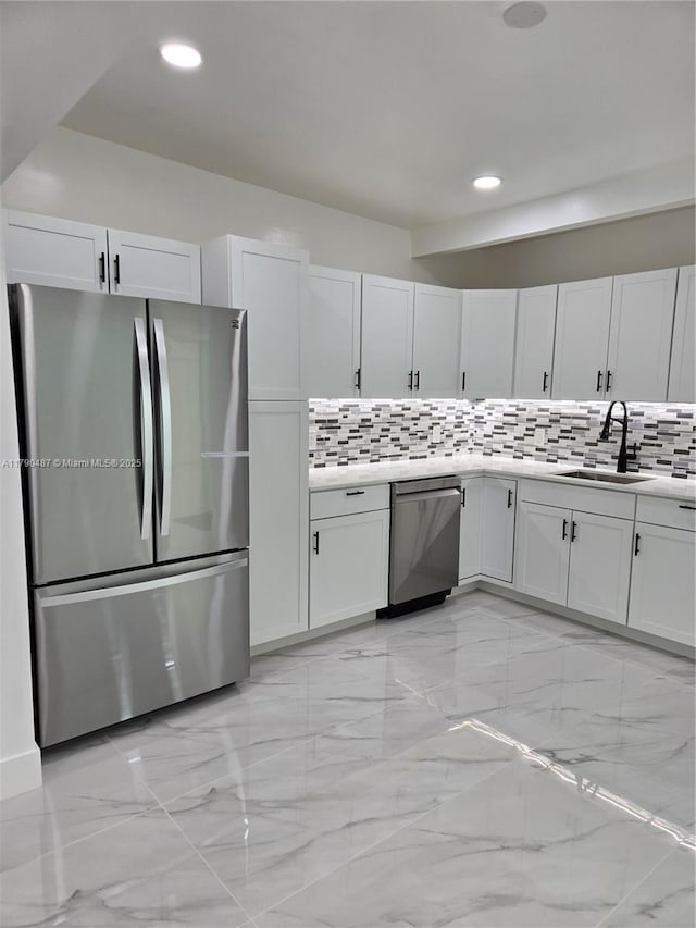 kitchen featuring marble finish floor, recessed lighting, a sink, backsplash, and stainless steel appliances