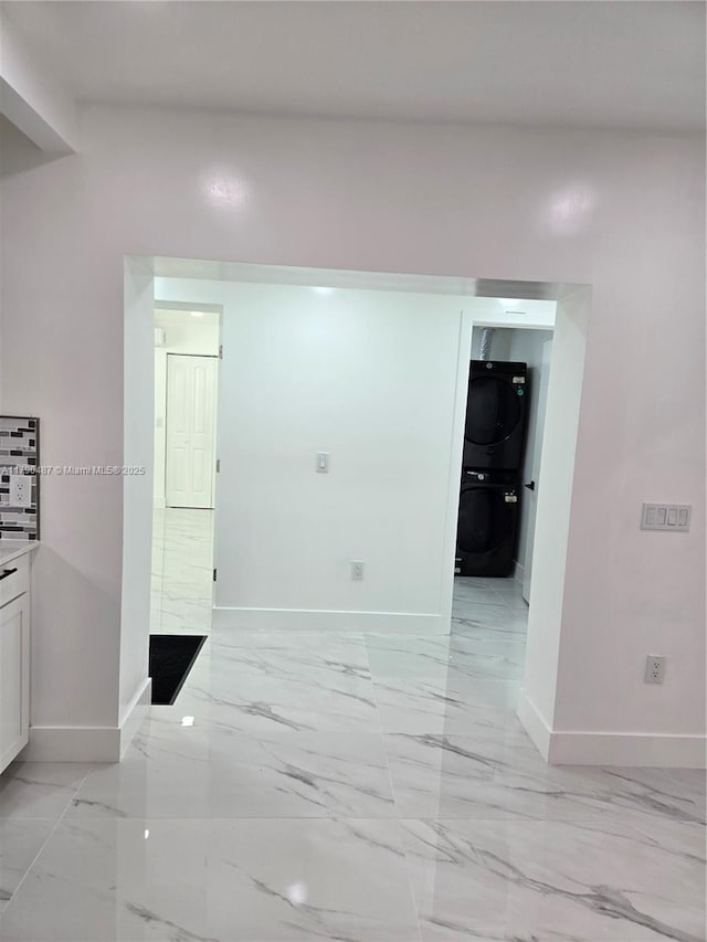 987 NE 145th St, North Miami, FL 33161 - hall with baseboards, light marble finish flooring, and stacked washer / dryer