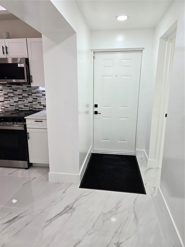 entryway featuring recessed lighting, baseboards, and marble finish floor