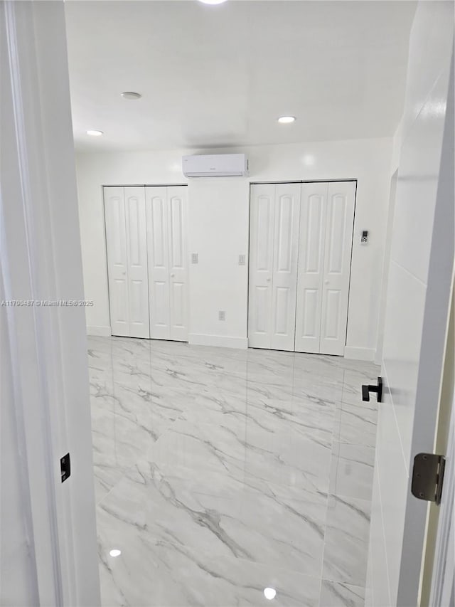 unfurnished bedroom with recessed lighting, baseboards, a wall mounted AC, and marble finish floor