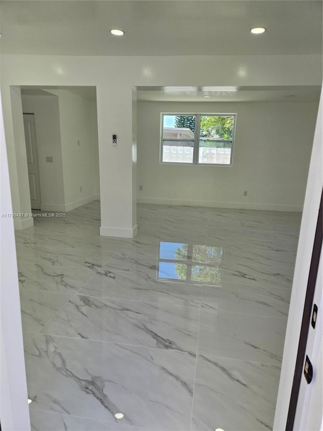 unfurnished room featuring baseboards, recessed lighting, and marble finish floor