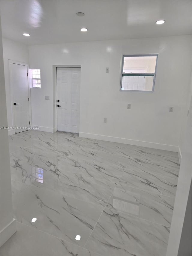spare room featuring baseboards, recessed lighting, and marble finish floor