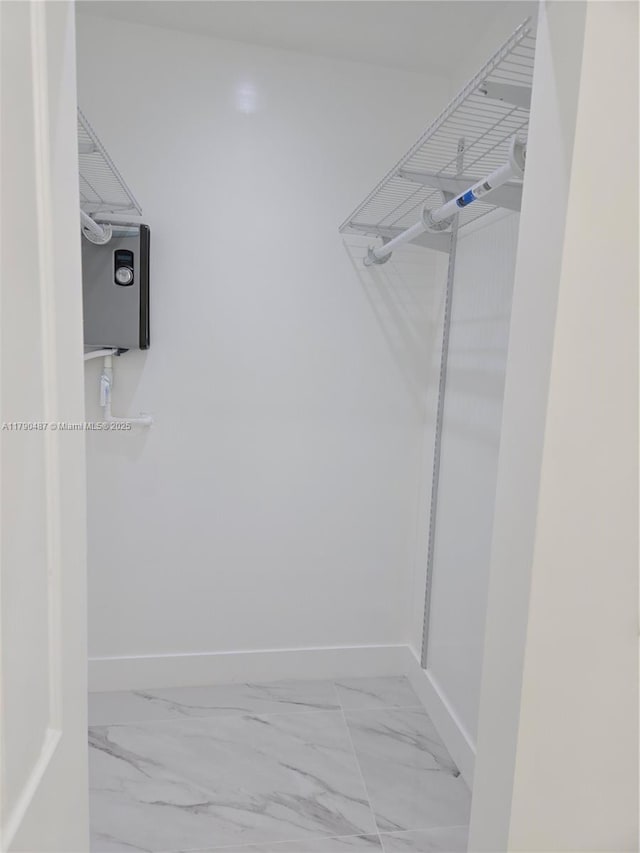 walk in closet with marble finish floor