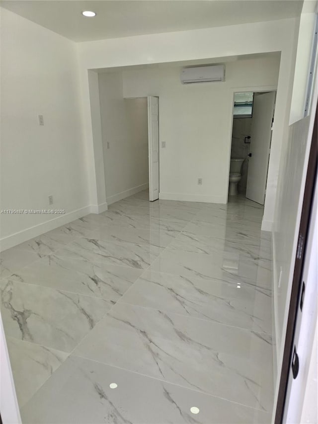 unfurnished room with recessed lighting, baseboards, a wall mounted AC, and marble finish floor