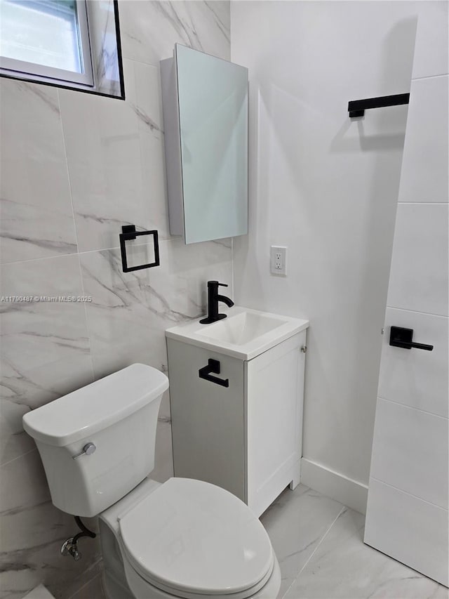 987 NE 145th St, North Miami, FL 33161 - bathroom featuring marble look tiles, toilet, vanity, and baseboards