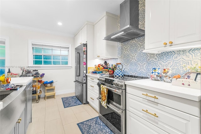 kitchen with decorative backsplash, wall chimney exhaust hood, appliances with stainless steel finishes, and light countertops