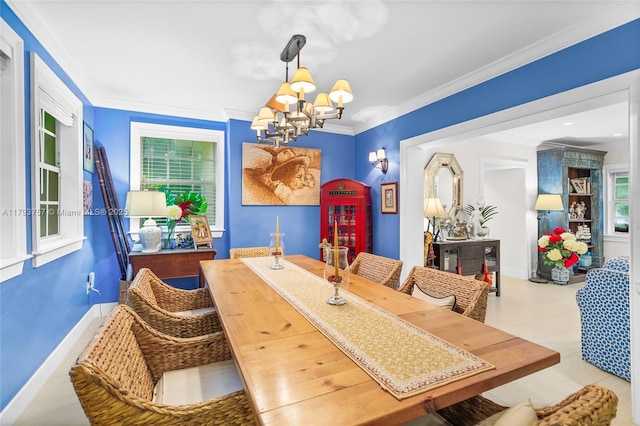 dining area featuring crown molding, baseboards, and a notable chandelier