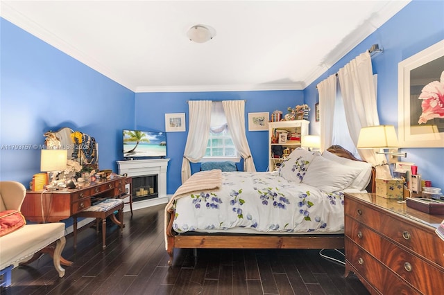 bedroom with crown molding, a glass covered fireplace, and wood finished floors
