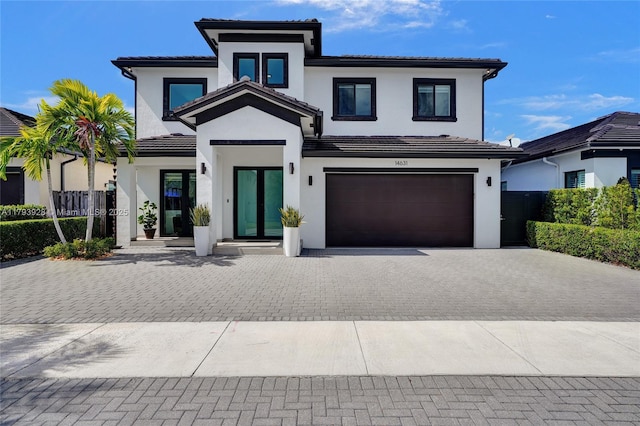view of front of home with an attached garage, decorative driveway, stucco siding, and a tile roof