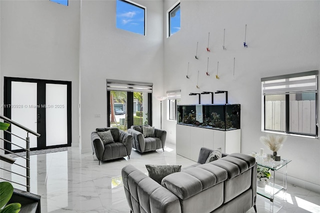 living room featuring stairs, a high ceiling, and marble finish floor