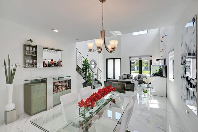 dining room with a dry bar, marble finish floor, and a notable chandelier