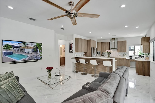 living area featuring recessed lighting, a ceiling fan, marble finish floor, and visible vents