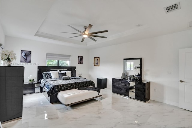 bedroom with marble finish floor, ceiling fan, visible vents, and a raised ceiling