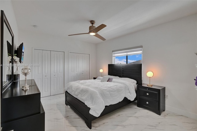 bedroom with two closets, a ceiling fan, baseboards, and marble finish floor