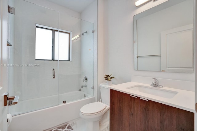 full bathroom featuring vanity, enclosed tub / shower combo, and toilet