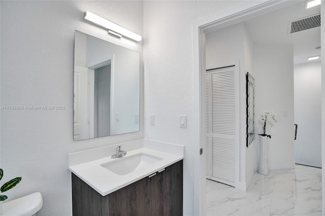 bathroom featuring visible vents, vanity, a closet, toilet, and marble finish floor