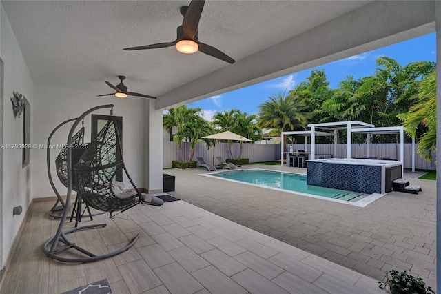 view of swimming pool featuring a ceiling fan, a patio area, a fenced in pool, a fenced backyard, and a jacuzzi