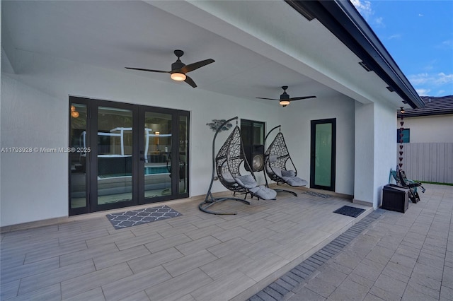 view of patio featuring french doors, fence, and ceiling fan