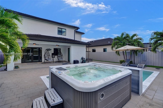 view of swimming pool with fence, a ceiling fan, a hot tub, and a patio area