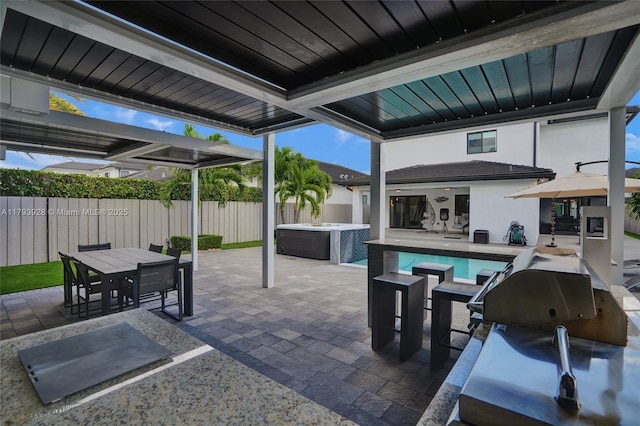 view of patio with a hot tub, fence, outdoor dining area, and a fenced in pool
