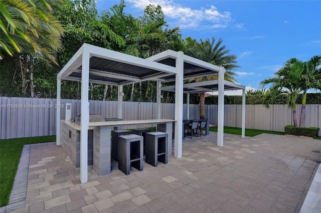 view of patio / terrace with a fenced backyard, outdoor dry bar, and a gazebo