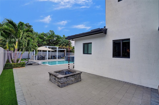 view of patio / terrace with a gazebo, a fenced in pool, a fire pit, and a fenced backyard