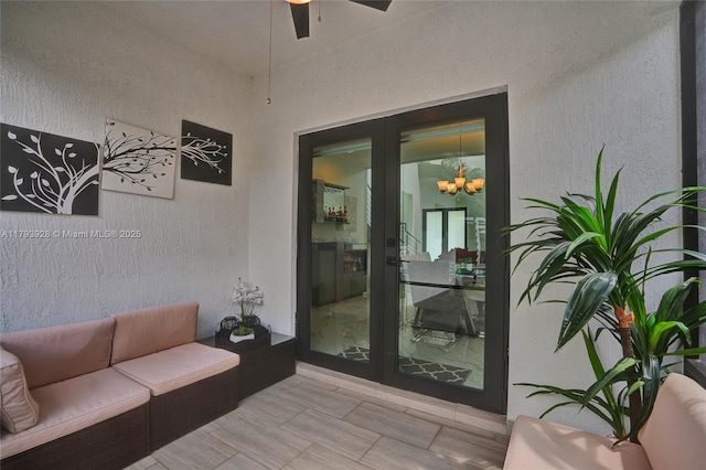 view of exterior entry featuring outdoor lounge area, a ceiling fan, and stucco siding