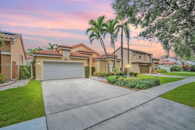 2724 Cayenne Ave, Cooper City, FL 33026 - mediterranean / spanish-style house with stucco siding, a tiled roof, concrete driveway, an attached garage, and a yard