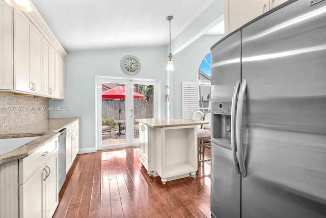 2724 Cayenne Ave, Cooper City, FL 33026 - kitchen with decorative backsplash, vaulted ceiling, light stone counters, wood-type flooring, and stainless steel appliances