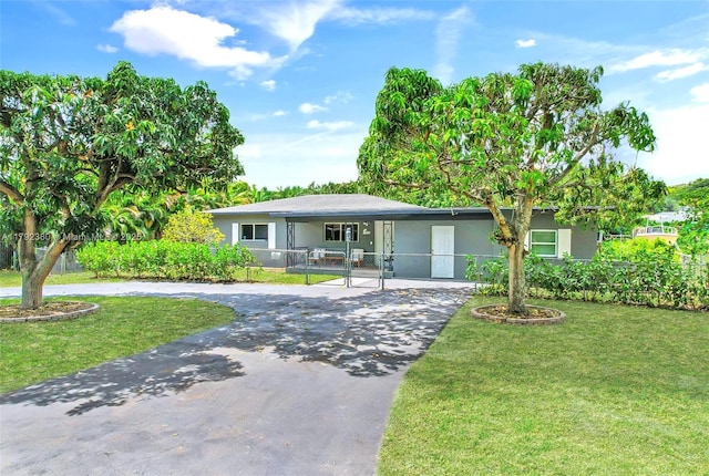 single story home with a front yard, a gate, fence private yard, curved driveway, and stucco siding