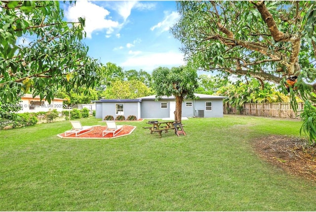 view of yard featuring fence and central AC