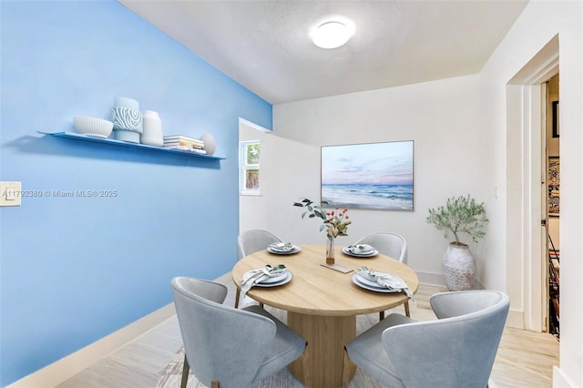 dining area featuring baseboards and wood finished floors