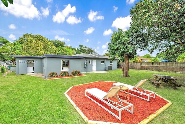 back of house featuring stucco siding, a patio area, fence, and a yard