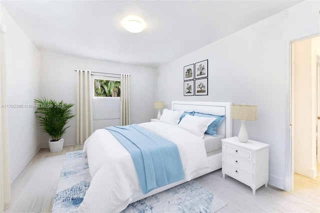 bedroom with baseboards and light wood-type flooring