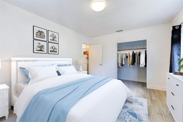 bedroom featuring a closet, baseboards, visible vents, and light wood-style floors