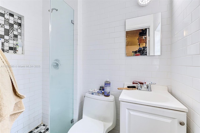 bathroom featuring vanity, toilet, tile walls, and a stall shower