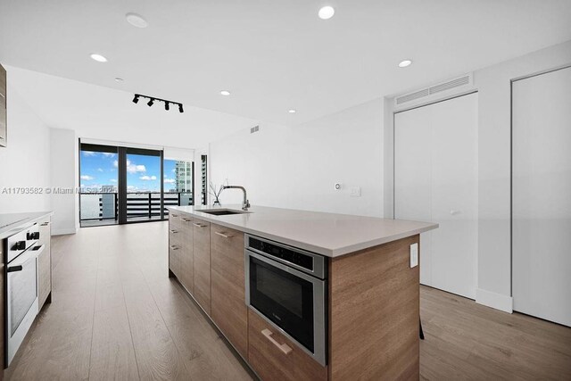 650 NE 32nd St Unit 1004, Miami, FL 33137 - kitchen featuring a wall of windows, track lighting, a sink, wood finished floors, and modern cabinets