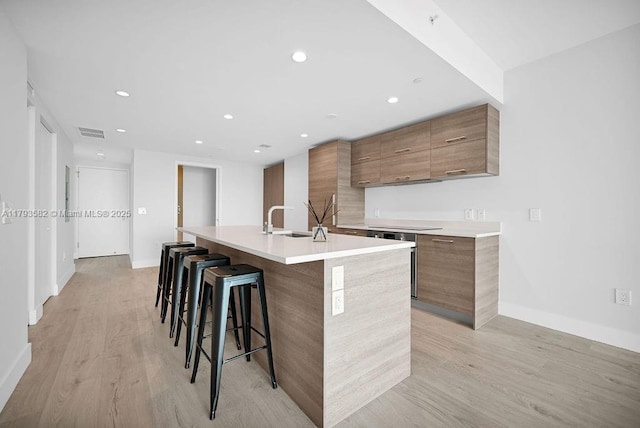 650 NE 32nd St Unit 1004, Miami, FL 33137 - kitchen featuring a kitchen island with sink, visible vents, modern cabinets, brown cabinets, and a sink