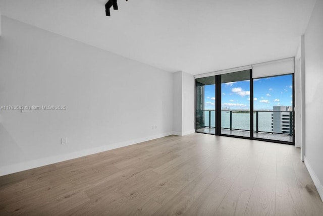 650 NE 32nd St Unit 1004, Miami, FL 33137 - spare room with baseboards, floor to ceiling windows, and wood finished floors
