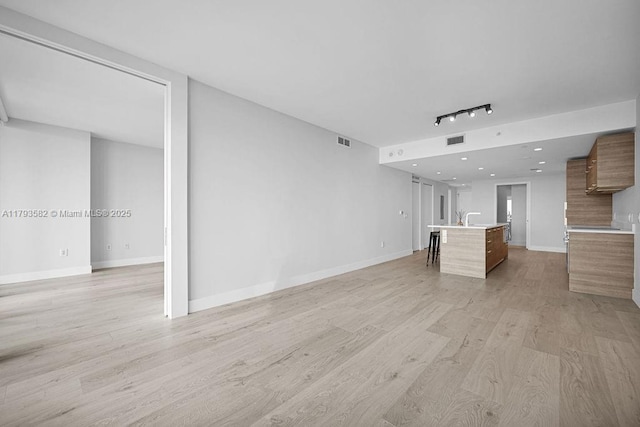 650 NE 32nd St Unit 1004, Miami, FL 33137 - unfurnished living room with visible vents, light wood-style floors, baseboards, and track lighting