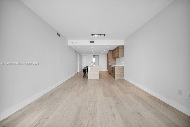 650 NE 32nd St Unit 1004, Miami, FL 33137 - unfurnished living room featuring visible vents, baseboards, and light wood-type flooring