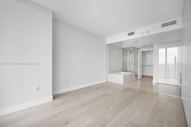 650 NE 32nd St Unit 1004, Miami, FL 33137 - unfurnished bedroom featuring light wood-style floors, connected bathroom, baseboards, and visible vents