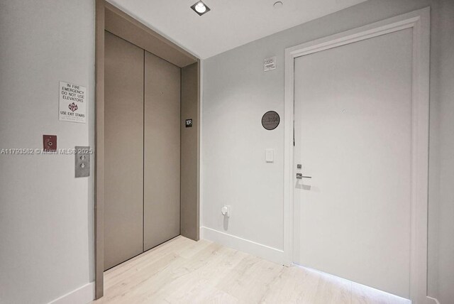 650 NE 32nd St Unit 1004, Miami, FL 33137 - hall featuring elevator, baseboards, and light wood-style floors