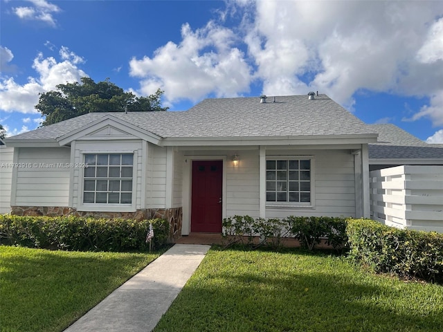 13776 SW 149 Circle Ln Unit 4-79, Miami, FL 33186 - view of front of property featuring a shingled roof, stone siding, and a front yard