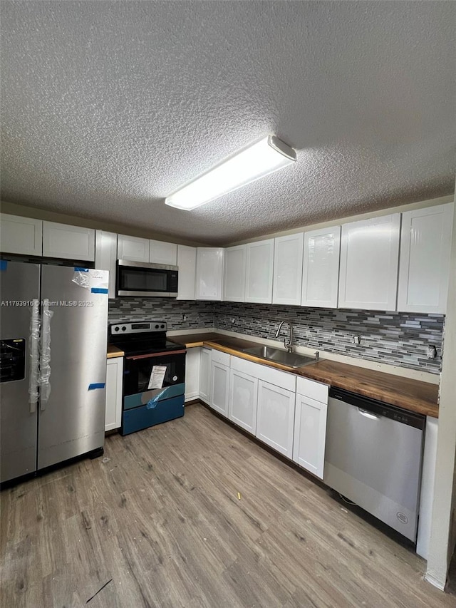 13776 SW 149 Circle Ln Unit 4-79, Miami, FL 33186 - kitchen with a sink, wood counters, light wood finished floors, and stainless steel appliances